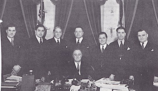 WHITE HOUSE VISIT, 1934. Standing behind President Franklin D. Roosevelt, at his desk: George C. Vournas, Harris J. Booras, U. S. Senator William King (Utah), P. S. Marthakis, Achilles Catsonis, George L. Pappas, Robert Katson, Chris E. Athas.