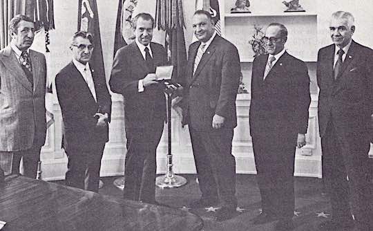 WHITE HOUSE 1971 - President Richard M. Nixon is presented an Ahepa gold medal commemorating the 150th anniversary of Greek Independence at the White House. With the President are: Supreme Vice President Sam Nakis, Supreme Secretary Dr. Michael N. Spirtos, President Nixon, Supreme President Louis G. Manesiotis, Supreme Treasurer William P. Tsaffaras, and Supreme Trustees Chairman Col. Peter N. Derzis.