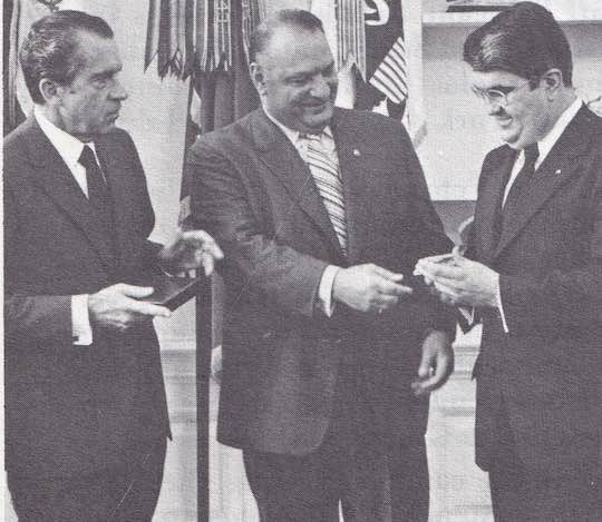 1971 - Tom C. Korologos, Deputy Assistant to President Richard M. Nixon, receives a silver Ahepa Medal commemorating the 150th anniversary of Greek Independence from Supreme President Manesiotis, while President Nixon looks on approvingly. Korologos is a member of the Salt Lake City Ahepa chapter.